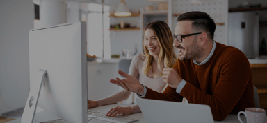 colleagues looking at computer and smiling