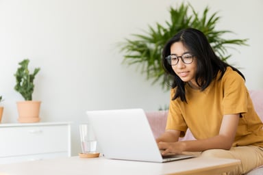 person with glasses working on a laptop