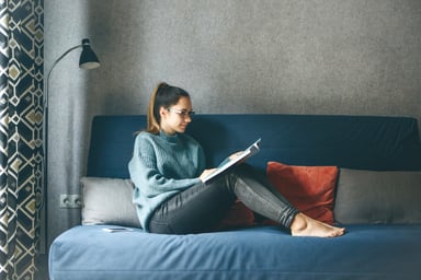 person reading an HR magazine on a couch
