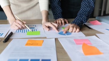 coworkers reading a chart considering how to choose the best HR system