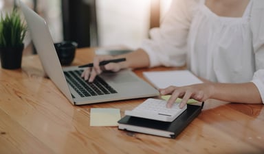 accountant researching payroll outsourcing companies on a laptop