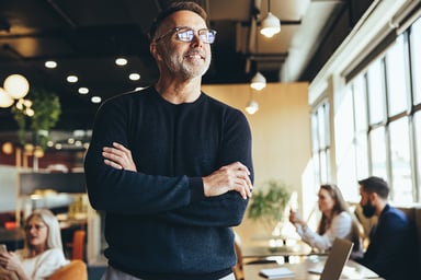 person crossing their arms and thinking in an office