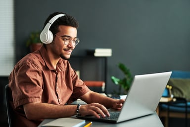 person working at laptop with headphones on